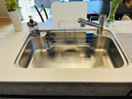 a kitchen sink with a dish drying rack in it at 村の小さなお宿　おきな in Tosa