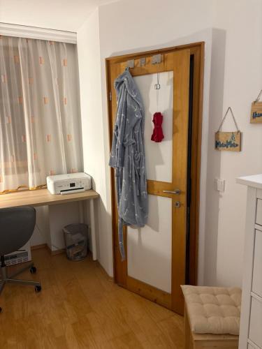 a door with a coat hanging on it next to a desk at Nice Room in City Centre in Hall in Tirol