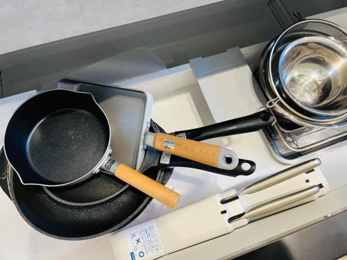 a table with a frying pan and utensils on it at 村の小さなお宿　おきな in Tosa