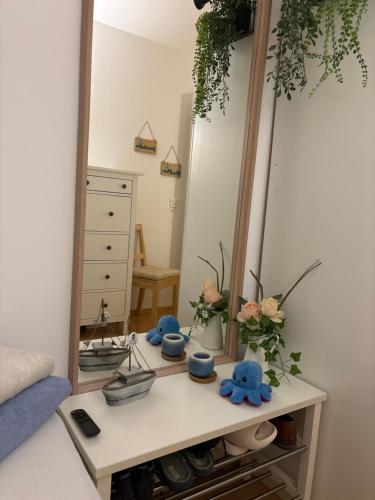 a dressing table with a mirror and flowers on it at Nice Room in City Centre in Hall in Tirol
