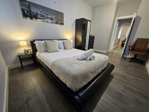 ein Schlafzimmer mit einem großen Bett mit weißer Bettwäsche und Kissen in der Unterkunft Nariken Apartments, Cardiff City Center in Cardiff