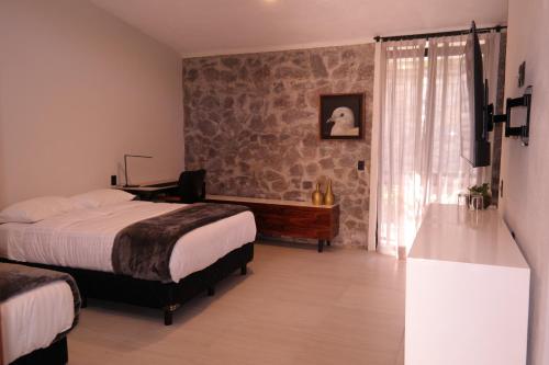 um quarto com 2 camas, uma secretária e uma janela em Quinta Pichón em Tepic