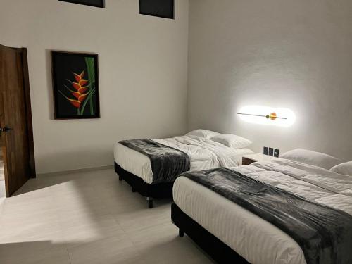 a hotel room with two beds and a lamp at Quinta Pichón in Tepic
