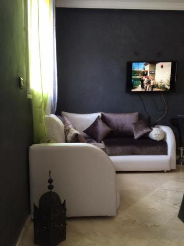 a living room with a white couch and a window at Etablissement moderne in Safi