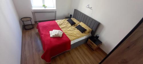 レグニツァにあるApartament Love on 5 - Miłość na 5の小さなベッドルーム(赤い毛布付きのベッド付)