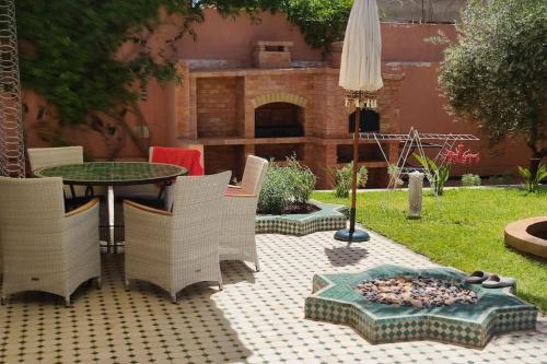 a patio with a table and chairs and a fire pit at Villa Palmengarten Meknès bei Fes in Meknès