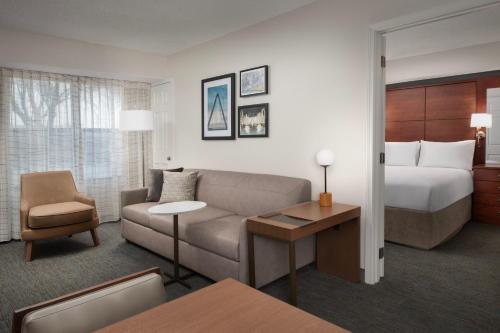 a hotel room with a couch and a bed at Residence Inn Kansas City Overland Park in Overland Park