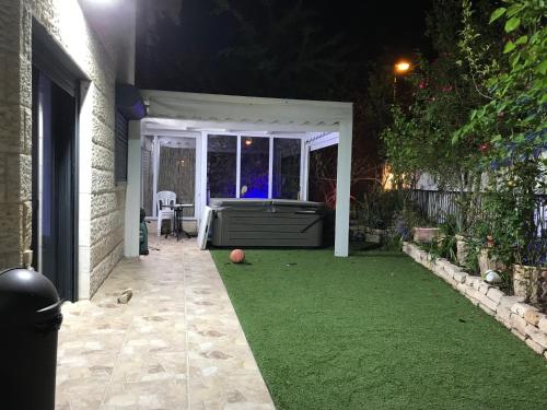 een achtertuin 's nachts met een voetbal op het gras bij Michael House in Jeruzalem