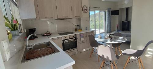a kitchen with a sink and a table with chairs at Christos in Kissamos