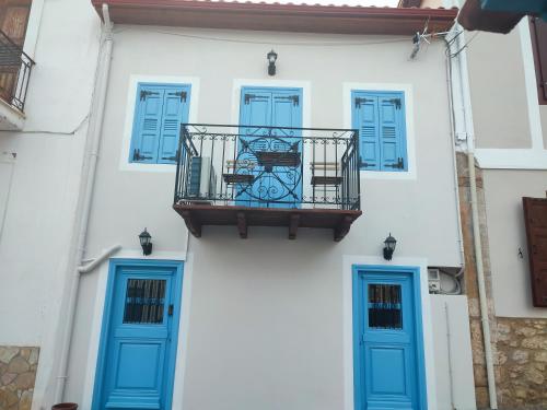 a white building with blue doors and a balcony at Loukas in Galaxidhion