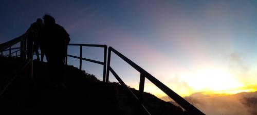a group of people standing on a hill with the sunset at FARILA LODGE in Kelimutu