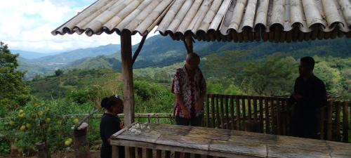 a group of people standing on a porch with a view at FARILA LODGE in Kelimutu