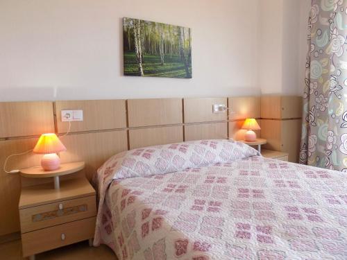 a bedroom with a bed and two lamps on tables at Playa R84MED010 in La Estación