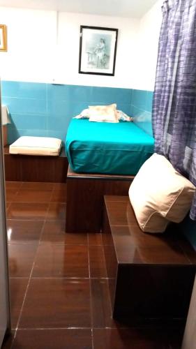 een kleine kamer met een bed en een blauwe matras bij Coliving 87 Estudio Numero 10 in Hospitalet de Llobregat