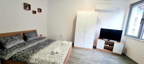 a bedroom with a bed and a flat screen tv at Lazy studio in Sofia
