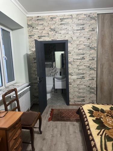 sypialnia z łazienką z kamienną ścianą w obiekcie Zaritap Guest House w mieście Zarritʼapʼ