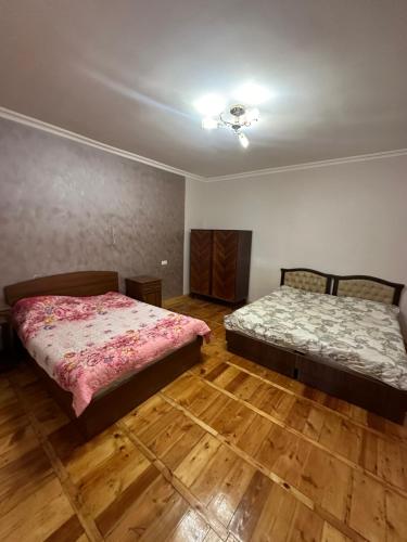 two beds in a room with wooden floors at Zaritap Guest House in Zarritʼapʼ