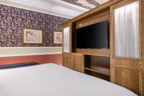 a bedroom with a bed and a flat screen tv at Hotel Palacio del Retiro, Autograph Collection in Madrid