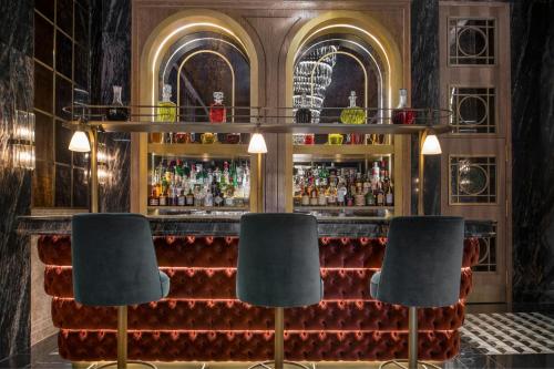 a bar with two chairs in front of a bar at Hotel Palacio del Retiro, Autograph Collection in Madrid