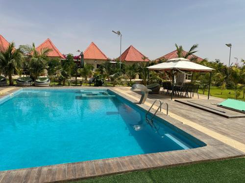 una grande piscina blu in un resort di Hôtel bergmann a Ouro Sogui