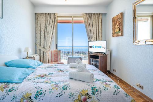 une chambre avec un grand lit avec une grande fenêtre dans l'établissement Spacieux appartement vue mer et montagne, à Cagnes-sur-Mer