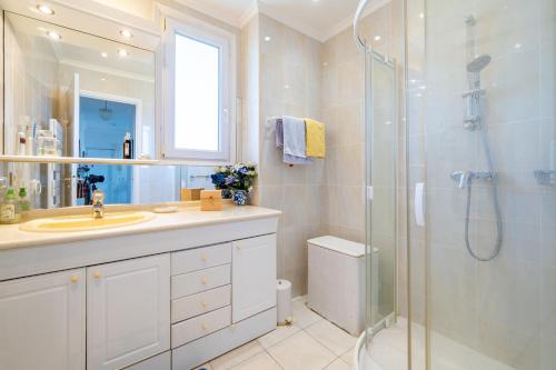 une salle de bain avec un lavabo et une douche en verre dans l'établissement Spacieux appartement vue mer et montagne, à Cagnes-sur-Mer