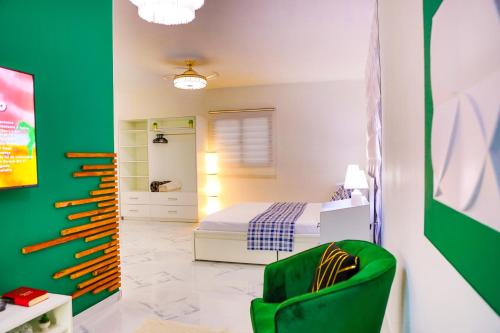 a bedroom with a bed and a green chair at Agapi Mou in Gaspar Hernández