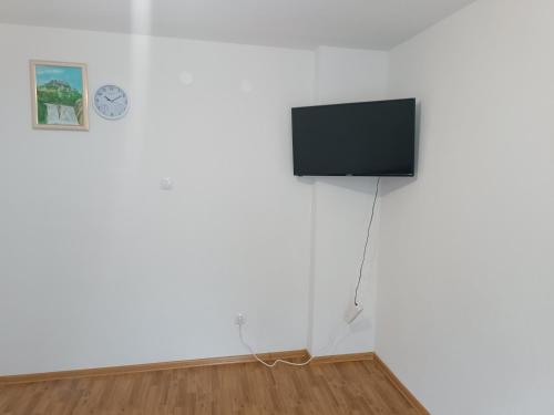 een flatscreen-tv op een witte muur in een kamer bij Apartmani CENTAR in Jajce