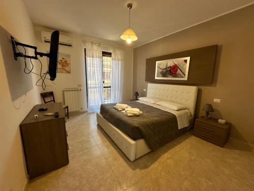 ein Schlafzimmer mit einem Bett und einem Fernseher darin in der Unterkunft Casa Cecilia(Villino da 2 a 8 persone) in Ladispoli