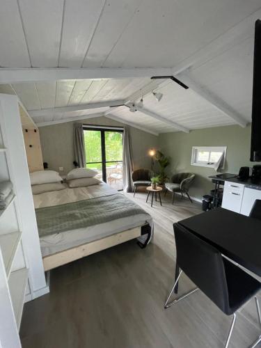 een slaapkamer met een groot bed en een bureau bij De Rode Zonnehoed in Scherpenzeel