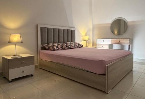 um quarto com uma cama grande e duas mesas de cabeceira em Luxury Inn: 3BR Amazing Garden View in Madinaty B6 em Madinaty