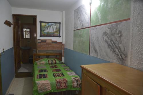 a small room with a bed and a table at Hotel Atenas Jericó in Jericó