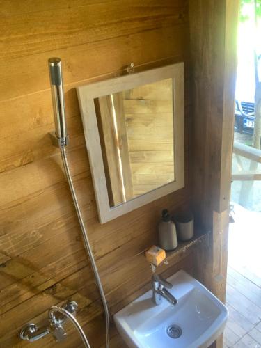 ein Badezimmer mit Waschbecken und Spiegel in der Unterkunft Magical Treehouse w sandy beach in Mostar