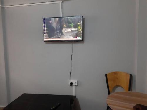 a flat screen tv hanging on a wall at The Alpha residence in Tema