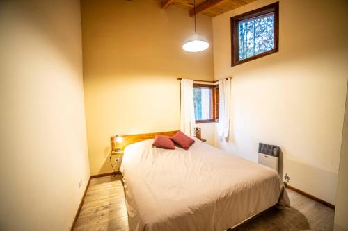 Schlafzimmer mit einem Bett und einem Fenster in der Unterkunft Casa en entorno de bosque, cerca de playas y cerros in San Carlos de Bariloche