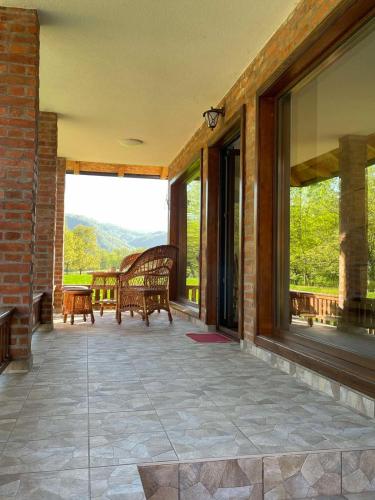 a screened in porch with a bench and windows at Drinsko Srce 2 in Ljubovija