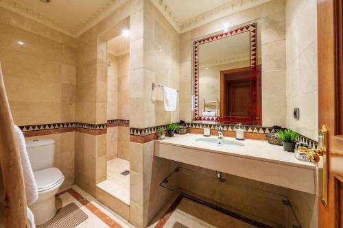 a bathroom with a toilet and a sink and a mirror at Appartement Chic Gueliz Plaza avec Vue in Marrakech