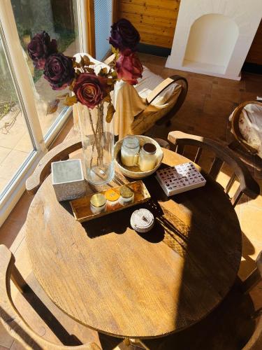 a wooden table with a vase and flowers on it at Kuća Šuma in Velika Buna