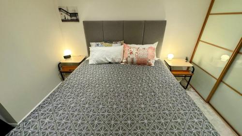 a large bed in a room with two tables at Entire Apartment in London in Bromley