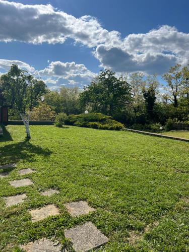 a grassy field with a stone pathway in a park at Kuća Šuma in Velika Buna