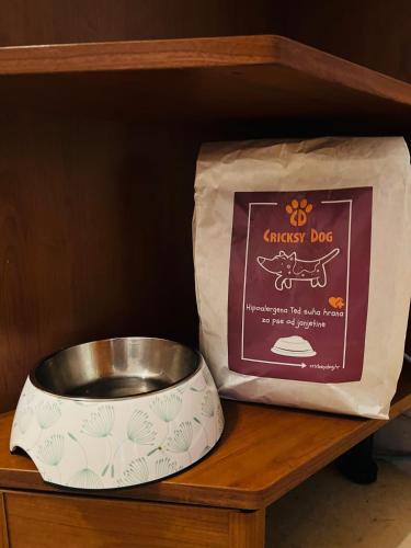 a bag of chicken dog food and a bowl on a shelf at Kuća Šuma in Velika Buna