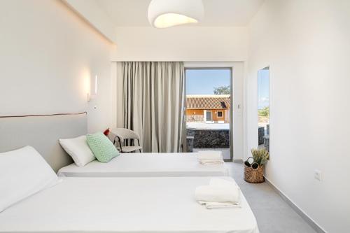 1 dormitorio blanco con 2 camas y ventana en Little Corfu, en Dassia