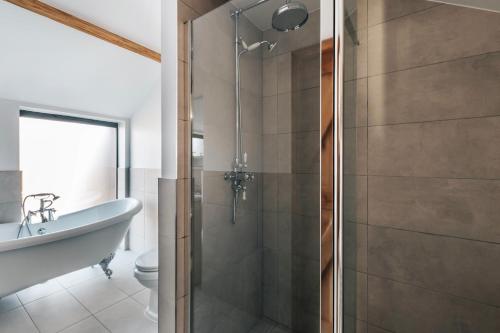 a bathroom with a shower and a toilet and a sink at The Linhay in Peterborough