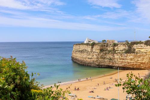 a group of people on a beach near the ocean at Apartment with 2 bedrooms, 2m to the beach in Armação de Pêra