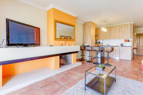 a living room with a fireplace with a tv on the wall at Apartment with 2 bedrooms, 2m to the beach in Armação de Pêra