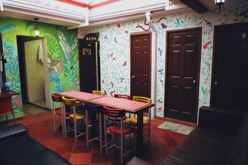 una mesa y sillas en una habitación con paredes coloridas en Usaquen Station Hostel, en Bogotá