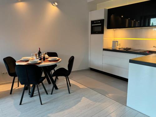 ein Esszimmer mit einem Tisch und Stühlen in einer Küche in der Unterkunft Black&White Angel Apartment in Krakau