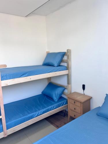 two bunk beds in a room with blue pillows at Santa Rosa hospedagem in Itu