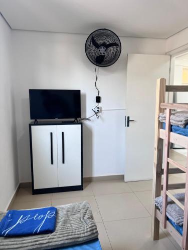 a room with a flat screen tv and a bed at Santa Rosa hospedagem in Itu