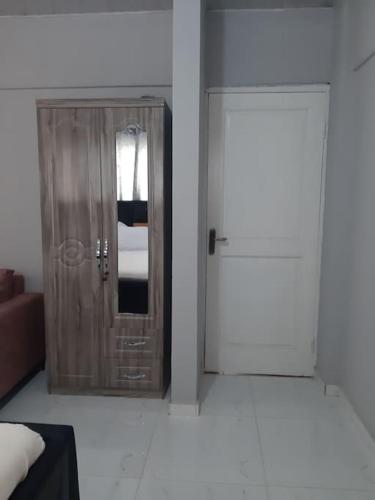 a room with a cabinet and a mirror and a couch at The Alpha* residence in Tema
